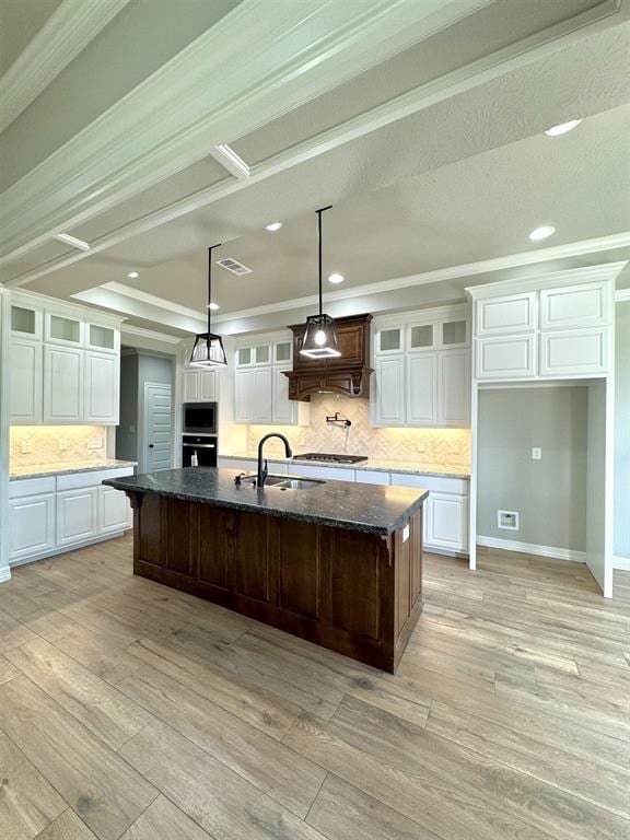 kitchen with white cabinetry, light wood finished floors, appliances with stainless steel finishes, and a sink