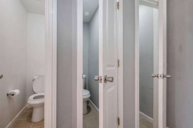 bathroom with tile patterned flooring, toilet, and baseboards