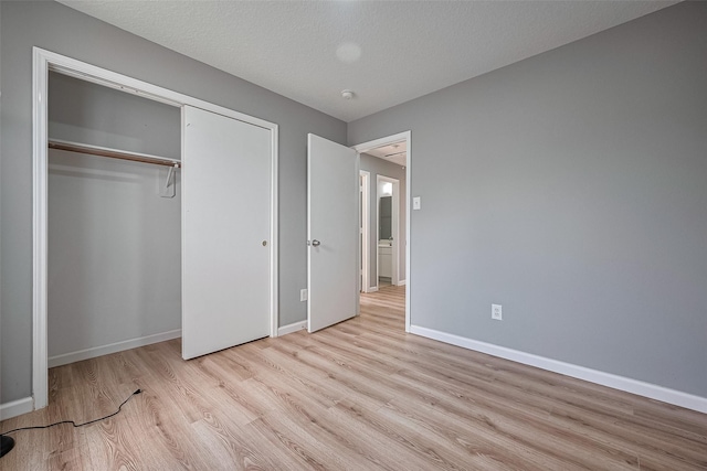 unfurnished bedroom featuring baseboards, a closet, and wood finished floors