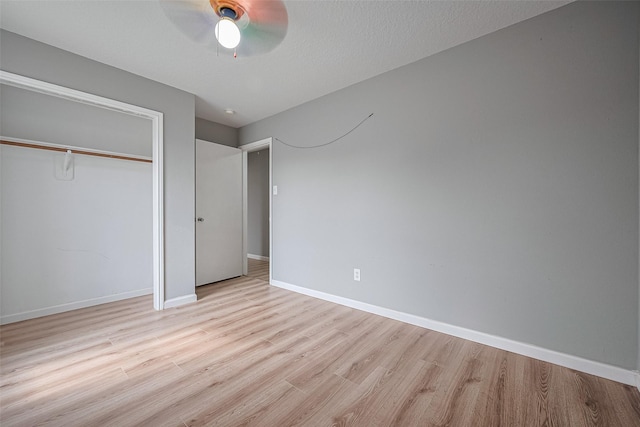 unfurnished bedroom featuring baseboards, a closet, ceiling fan, and wood finished floors