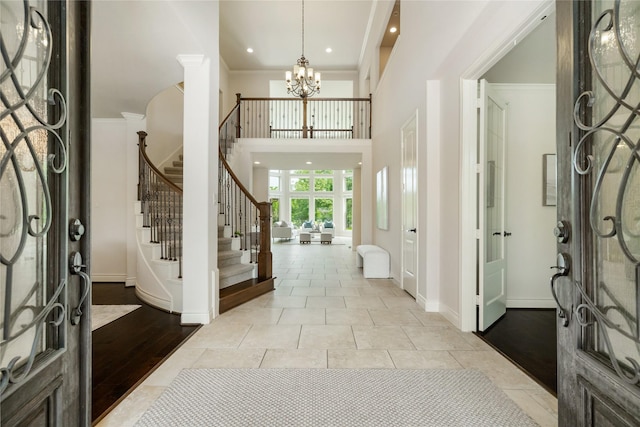 18538 Wade Creek Ln, Cypress, TX 77433 - foyer featuring an inviting chandelier, light tile patterned floors, a high ceiling, stairway, and baseboards