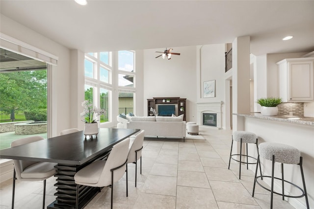 18538 Wade Creek Ln, Cypress, TX 77433 - dining room featuring light tile patterned flooring, a ceiling fan, a glass covered fireplace, and recessed lighting