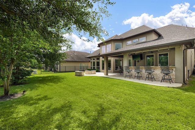 18538 Wade Creek Ln, Cypress, TX 77433 - rear view of house featuring stucco siding, a lawn, outdoor dry bar, a fenced backyard, and a patio area