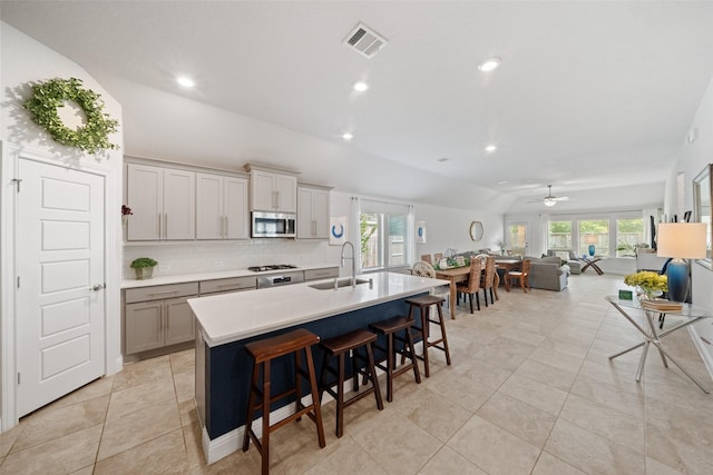 18740 Laurel Hills Dr, New Caney, TX 77357 - kitchen featuring a sink, tasteful backsplash, visible vents, open floor plan, and appliances with stainless steel finishes