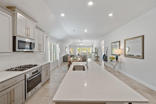 18740 Laurel Hills Dr, New Caney, TX 77357 - kitchen featuring a ceiling fan, a sink, open floor plan, stainless steel appliances, and a kitchen island with sink