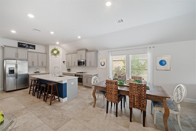 18740 Laurel Hills Dr, New Caney, TX 77357 - kitchen with a center island with sink, stainless steel appliances, a sink, and gray cabinets