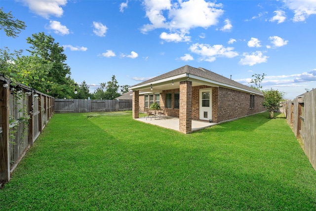 18740 Laurel Hills Dr, New Caney, TX 77357 - rear view of property featuring a yard, a patio, brick siding, and a fenced backyard