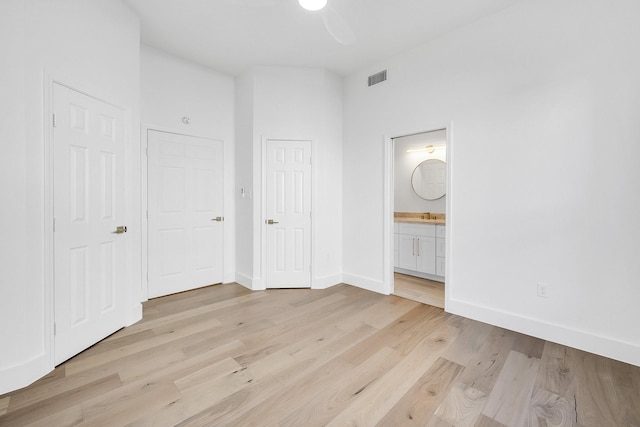 686 Edgewood Dr, Montgomery, TX 77356 - unfurnished bedroom with light wood-type flooring, visible vents, baseboards, and ensuite bathroom