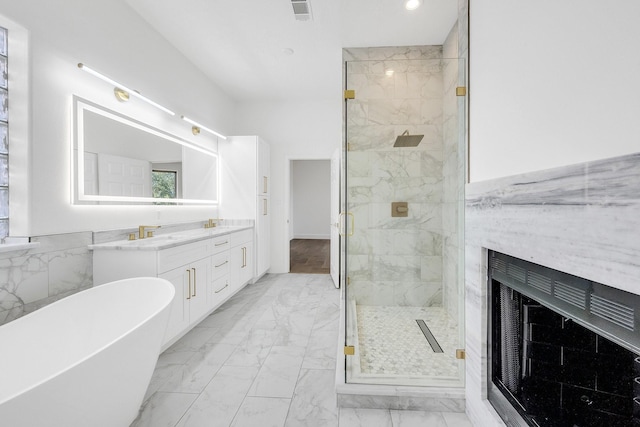 686 Edgewood Dr, Montgomery, TX 77356 - bathroom featuring a marble finish shower, a fireplace, a soaking tub, visible vents, and marble finish floor