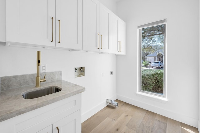 686 Edgewood Dr, Montgomery, TX 77356 - clothes washing area with baseboards, a sink, washer hookup, cabinet space, and electric dryer hookup