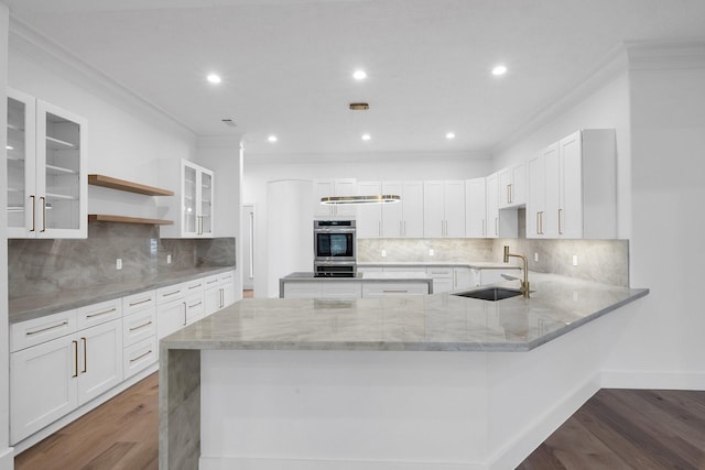 686 Edgewood Dr, Montgomery, TX 77356 - kitchen with light stone countertops, crown molding, a sink, and wood finished floors