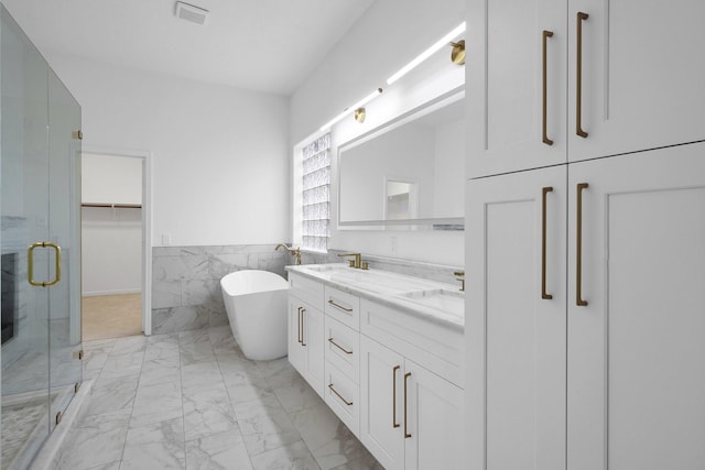 686 Edgewood Dr, Montgomery, TX 77356 - full bathroom featuring tile walls, visible vents, a shower stall, a freestanding tub, and marble finish floor