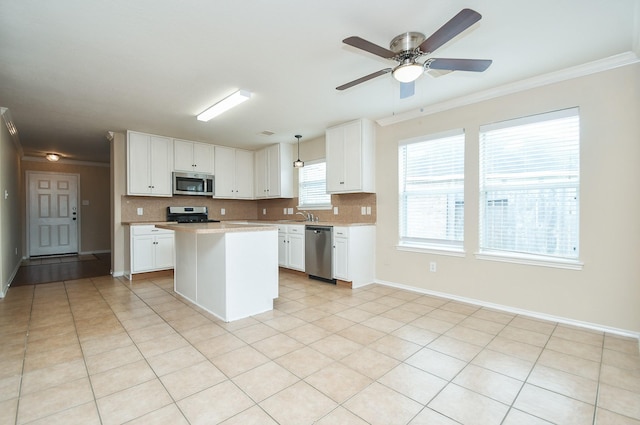 19826 Seagler Glen Ln, Katy, TX 77449 - kitchen with stainless steel appliances, crown molding, light countertops, backsplash, and white cabinetry