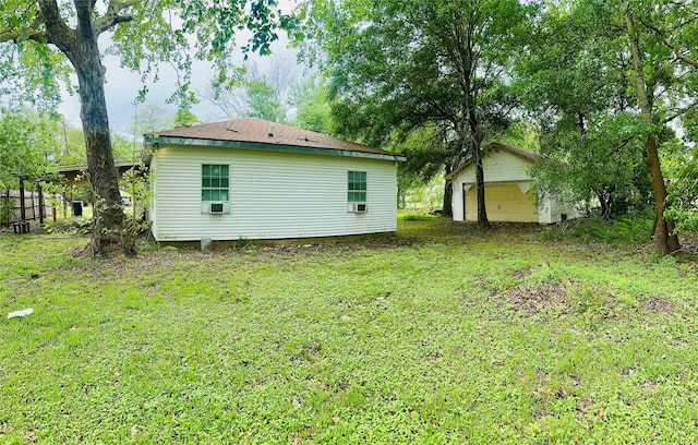 rear view of house with a yard, an outdoor structure, and cooling unit