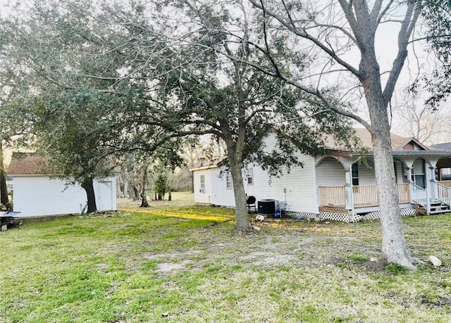 view of yard with a porch and central AC