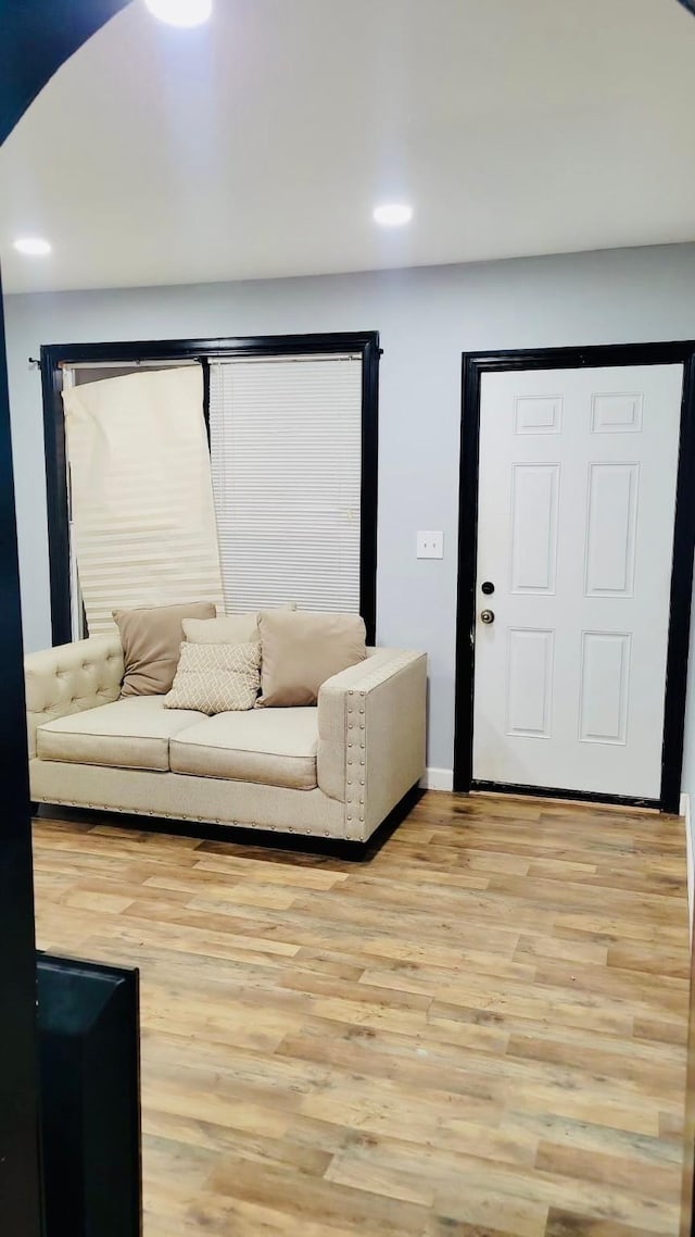 living area featuring light wood-style flooring, baseboards, and recessed lighting