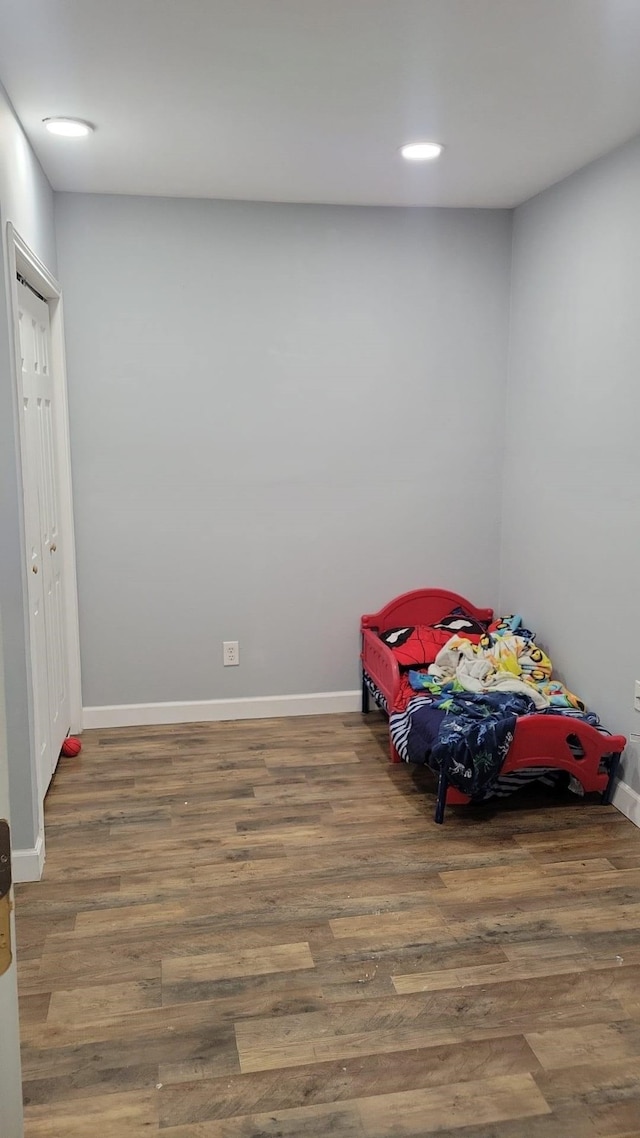 unfurnished bedroom with baseboards, recessed lighting, and wood finished floors