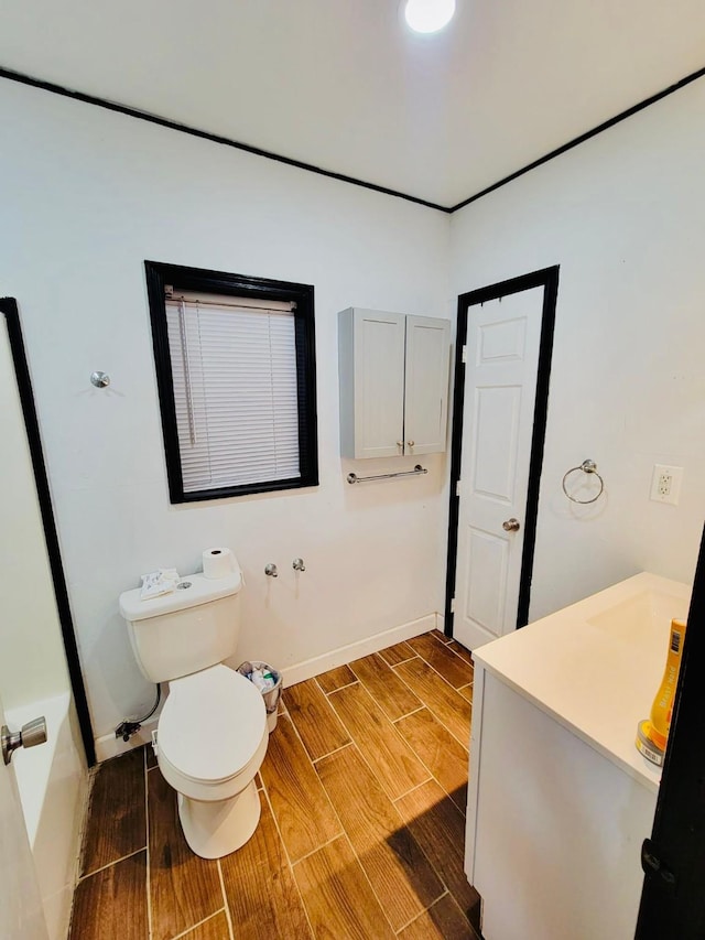 bathroom featuring toilet, baseboards, and wood finished floors