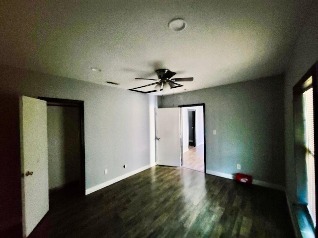 unfurnished bedroom with baseboards, ceiling fan, visible vents, and wood finished floors