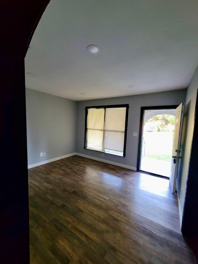 spare room featuring recessed lighting, baseboards, and dark wood-style floors