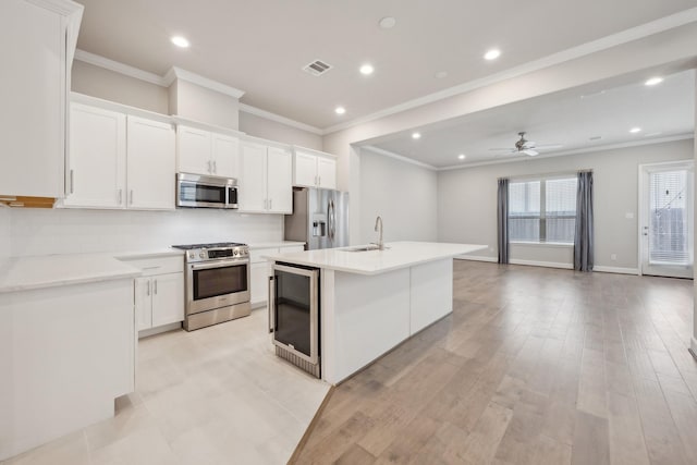 5432 Nolda St, Houston, TX 77007 - kitchen with wine cooler, visible vents, white cabinetry, a center island with sink, and appliances with stainless steel finishes
