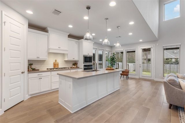 318 Mistletoe Ridge Ct, Montgomery, TX 77316 - kitchen with recessed lighting, light wood finished floors, visible vents, a sink, and backsplash