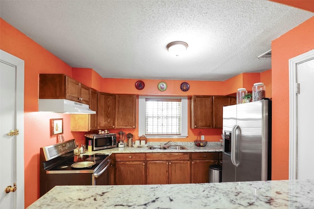 kitchen featuring brown cabinets, stainless steel appliances, a sink, and under cabinet range hood