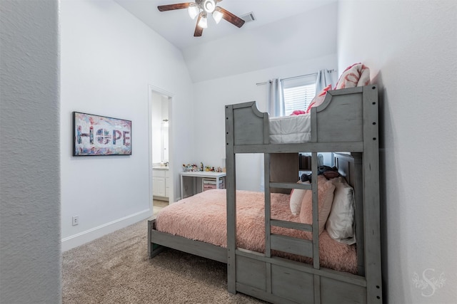 bedroom featuring vaulted ceiling, carpet floors, connected bathroom, baseboards, and ceiling fan