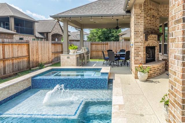 view of pool with an outdoor brick fireplace, area for grilling, a patio area, a fenced backyard, and a pool with connected hot tub