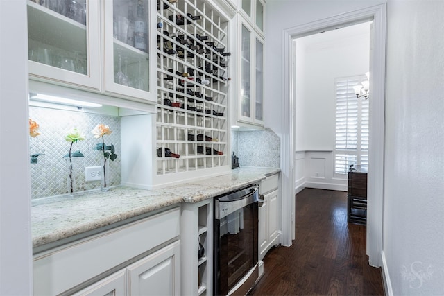 kitchen featuring beverage cooler, dark wood-style flooring, white cabinets, light stone countertops, and decorative backsplash