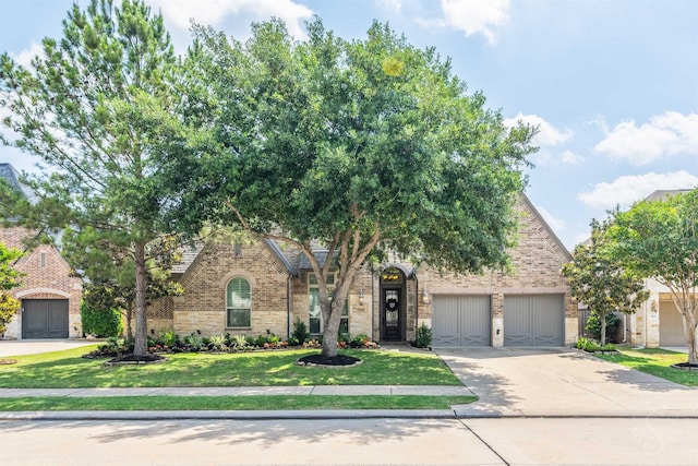 view of front of property featuring brick siding, driveway, and a front yard
