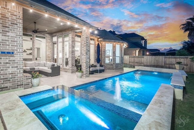 pool at dusk with an outdoor living space, ceiling fan, a fenced backyard, and a patio area