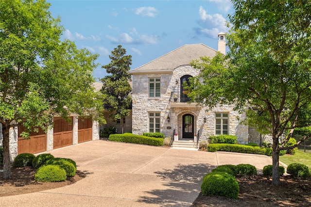 508 Golden Bear Dr, Austin, TX 78738 - french country style house featuring stone siding, driveway, and a chimney