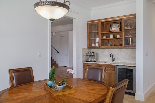 508 Golden Bear Dr, Austin, TX 78738 - dining room with indoor wet bar, wine cooler, stairway, crown molding, and baseboards