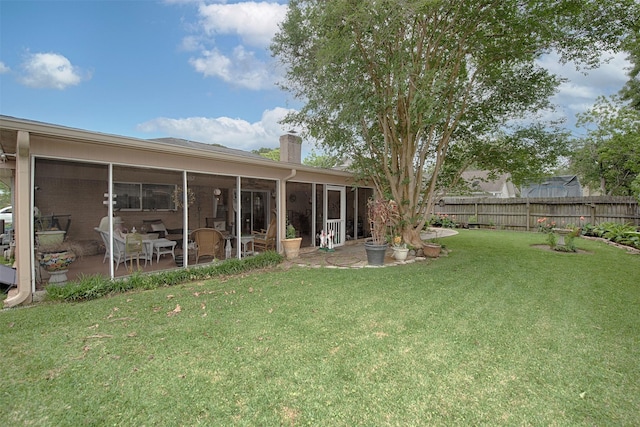 view of yard featuring fence and a sunroom