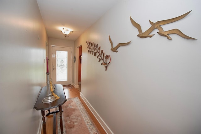 hallway with baseboards and light wood-style flooring