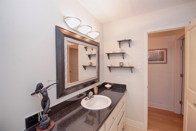 bathroom featuring baseboards, vanity, and wood finished floors