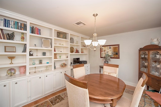 dining area with ornamental molding, a notable chandelier, light wood-type flooring, and visible vents