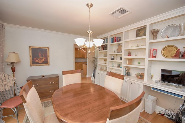 dining room featuring light wood finished floors, ornamental molding, a notable chandelier, and visible vents