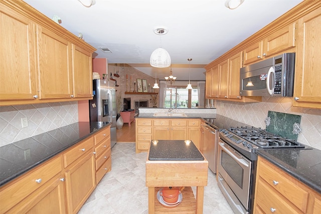 kitchen featuring visible vents, a sink, open floor plan, a peninsula, and stainless steel appliances