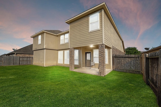 1902 Red Cedar Trl, Rosenberg, TX 77471 - back of house at dusk with a yard, a patio area, and a fenced backyard