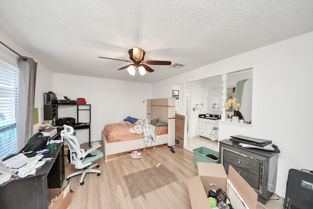 6230 Grandvale Dr, Houston, TX 77072 - bedroom with ceiling fan, light wood finished floors, visible vents, and a textured ceiling