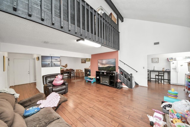 6230 Grandvale Dr, Houston, TX 77072 - living area featuring stairs, visible vents, high vaulted ceiling, and wood finished floors