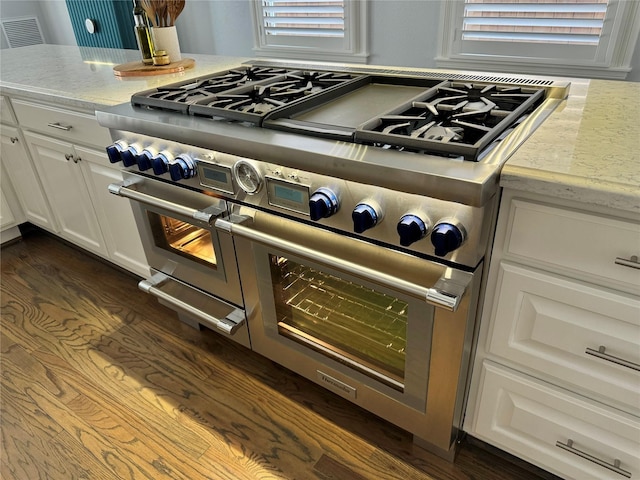 1905 W 14th St Unit B, Houston, TX 77008 - room details featuring light stone countertops, dark wood-style flooring, double oven range, visible vents, and white cabinetry