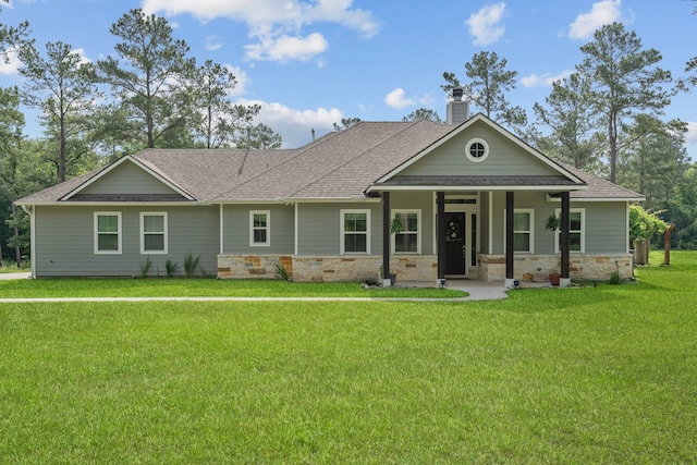 craftsman inspired home featuring covered porch, stone siding, a chimney, a front lawn, and roof with shingles