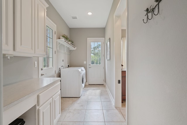 laundry room featuring washing machine and dryer, light tile patterned floors, baseboards, visible vents, and cabinet space