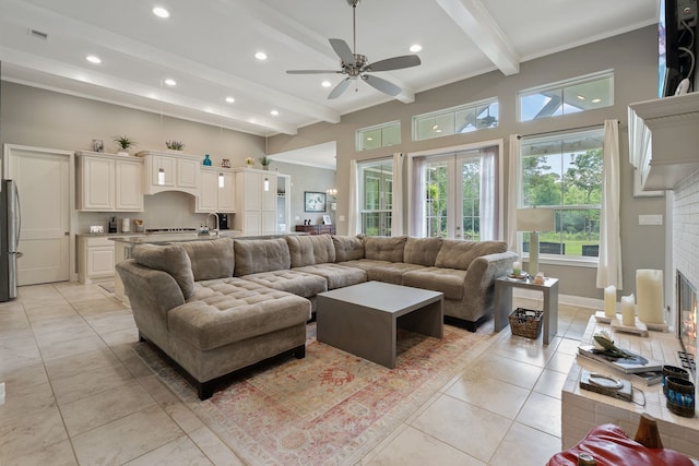 living area with recessed lighting, a glass covered fireplace, ceiling fan, light tile patterned flooring, and beamed ceiling