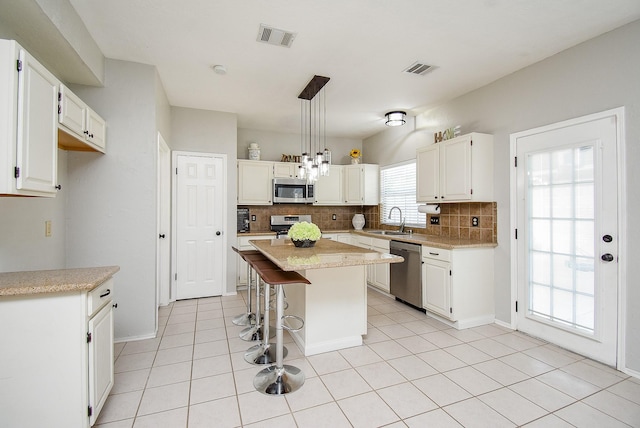 210 Needleleaf Ln, Sugar Land, TX 77479 - kitchen featuring appliances with stainless steel finishes, a sink, tasteful backsplash, and white cabinets