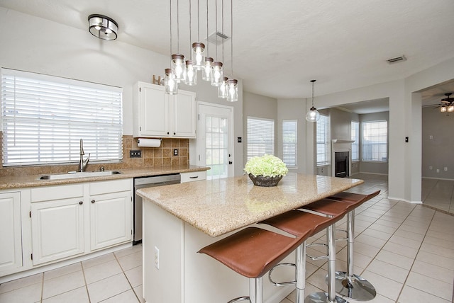 210 Needleleaf Ln, Sugar Land, TX 77479 - kitchen featuring dishwasher, a sink, light tile patterned floors, and a center island
