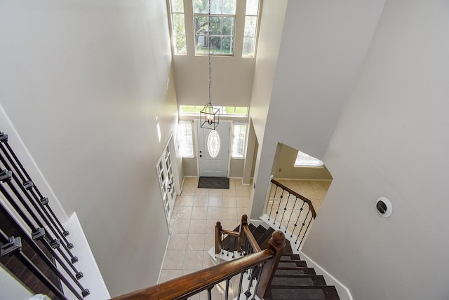 210 Needleleaf Ln, Sugar Land, TX 77479 - staircase with a towering ceiling, healthy amount of natural light, tile patterned flooring, and baseboards